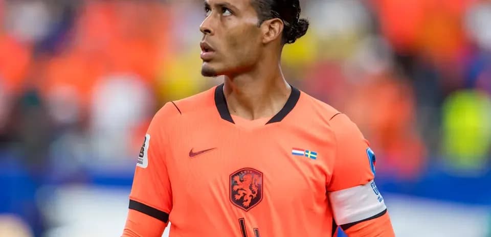Jugador de fútbol con camiseta naranja mirando hacia arriba