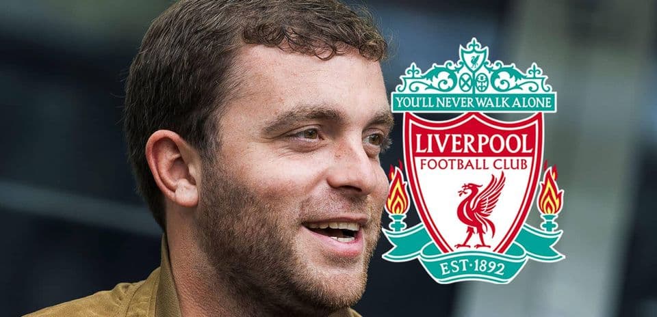 Hombre sonriendo con logo del Liverpool FC de fondo