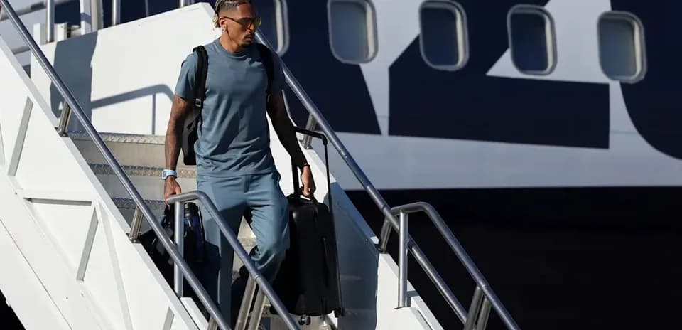 Jugador bajando del avión con maleta