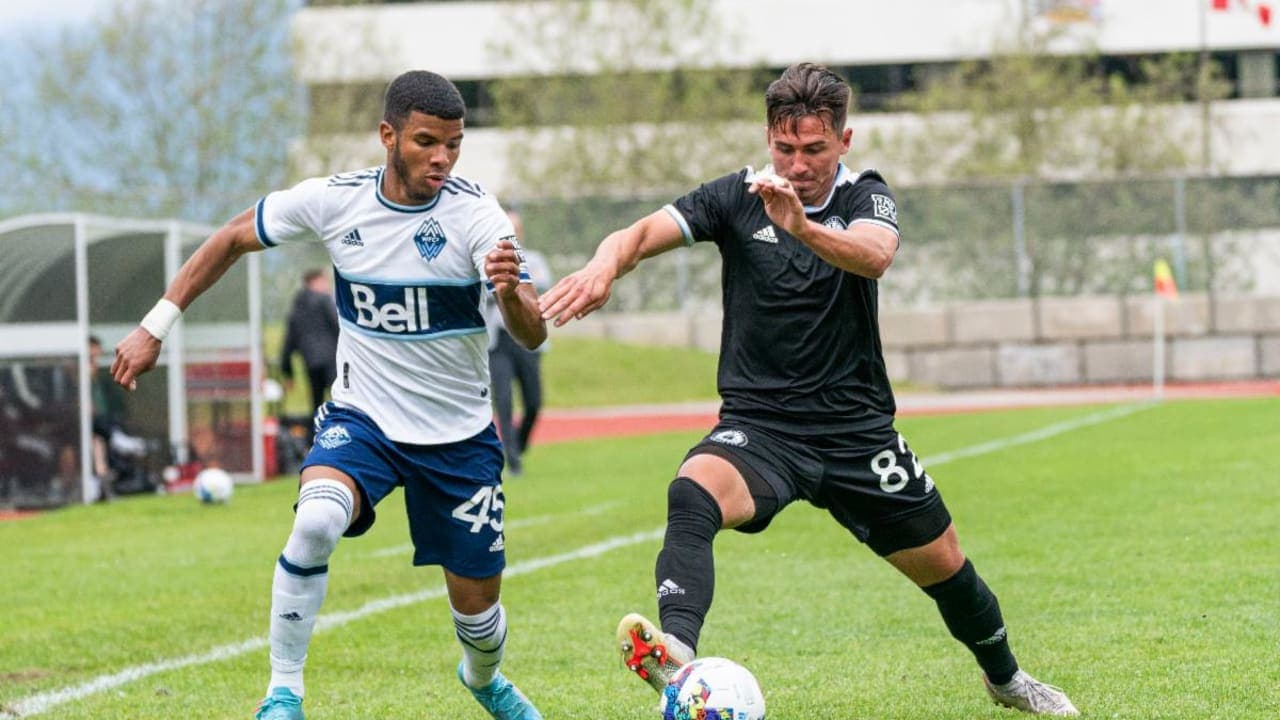 Dos jugadores compitiendo por el balón en el partido