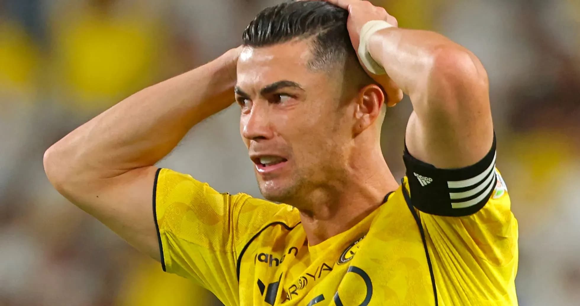 Jugador con camiseta amarilla sosteniendo la cabeza