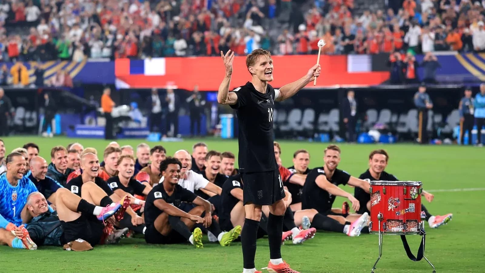 Jugador celebrando con equipo sentado en el campo