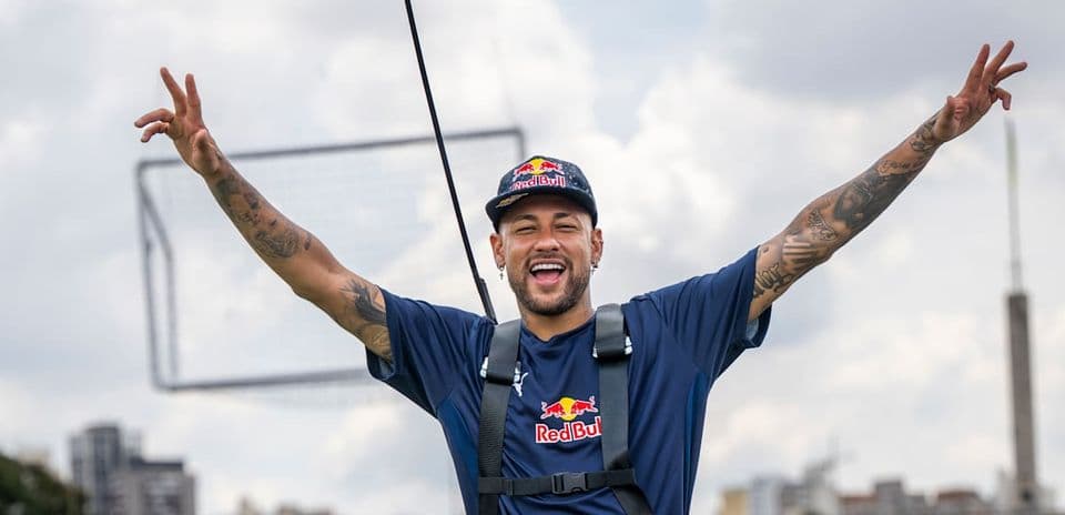 Neymar sonriendo con brazos levantados en evento