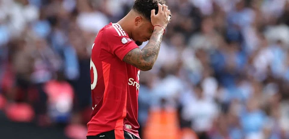 Jugador con camiseta roja mostrando frustración en el campo