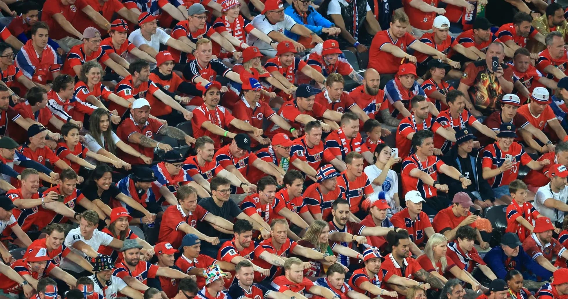 Aficionados en la grada animando en uniforme rojo