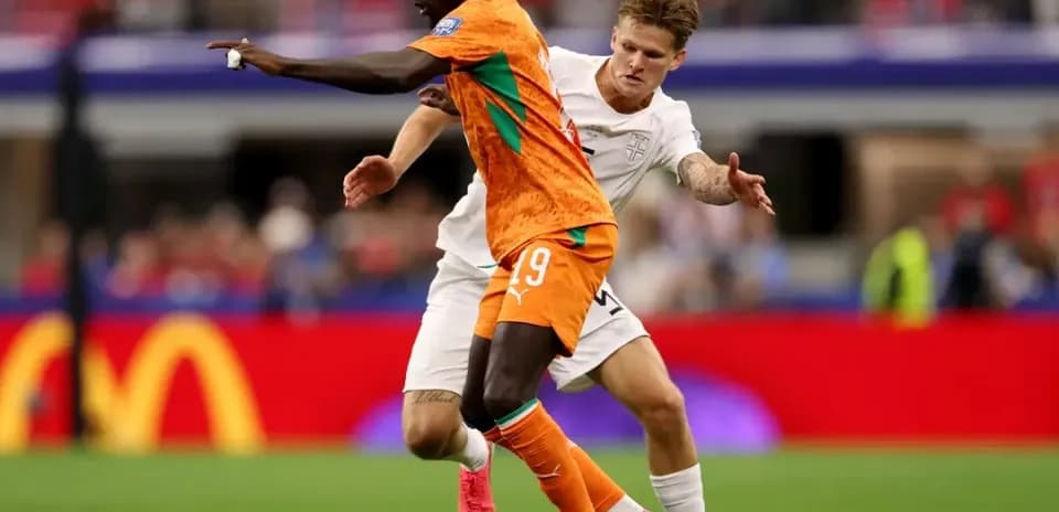 Jugador de Costa de Marfil driblando a rival inglés