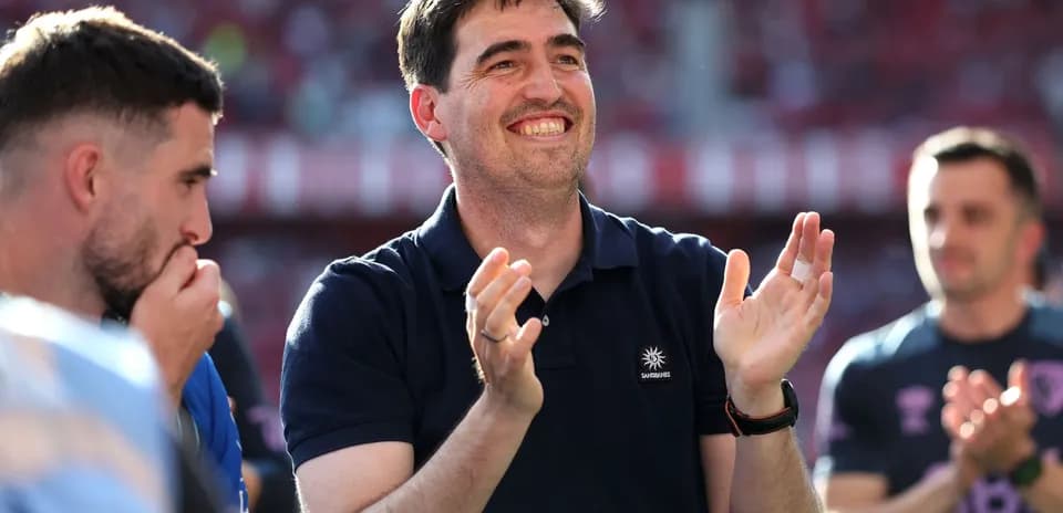 Entrenador aplaudiendo junto a jugadores en el campo