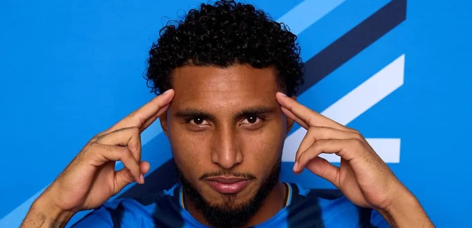 Jugador posando con fondo azul y camiseta rayada
