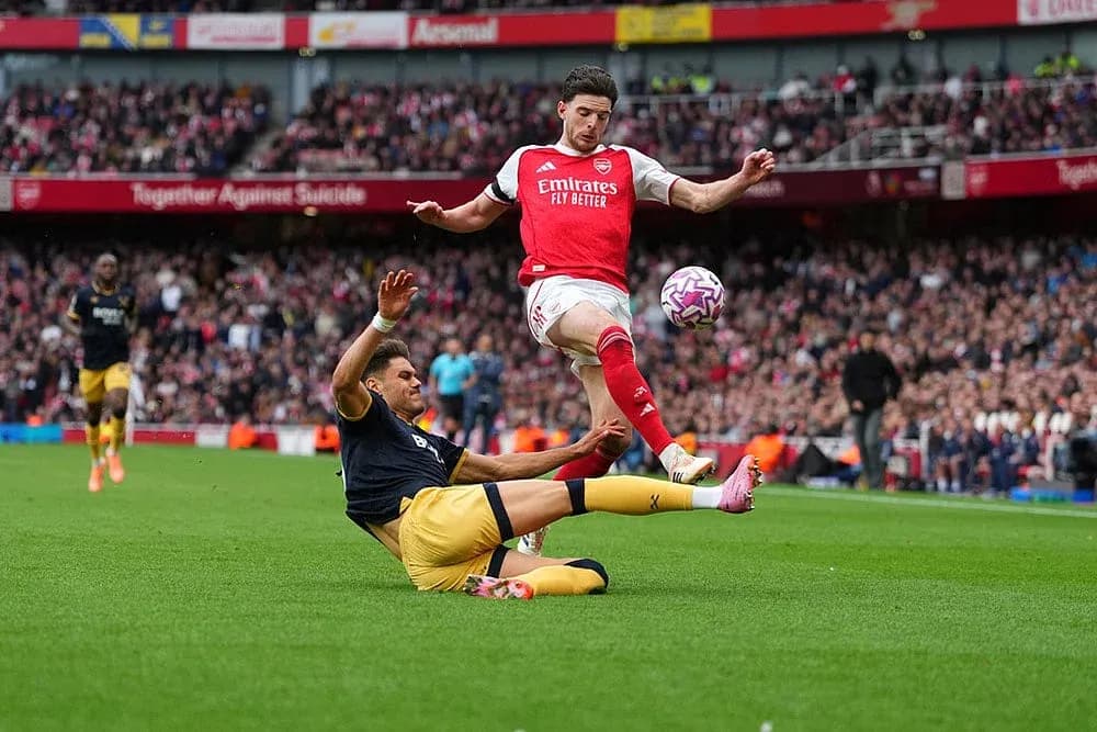 Jugador de Arsenal saltando sobre rival de West Ham
