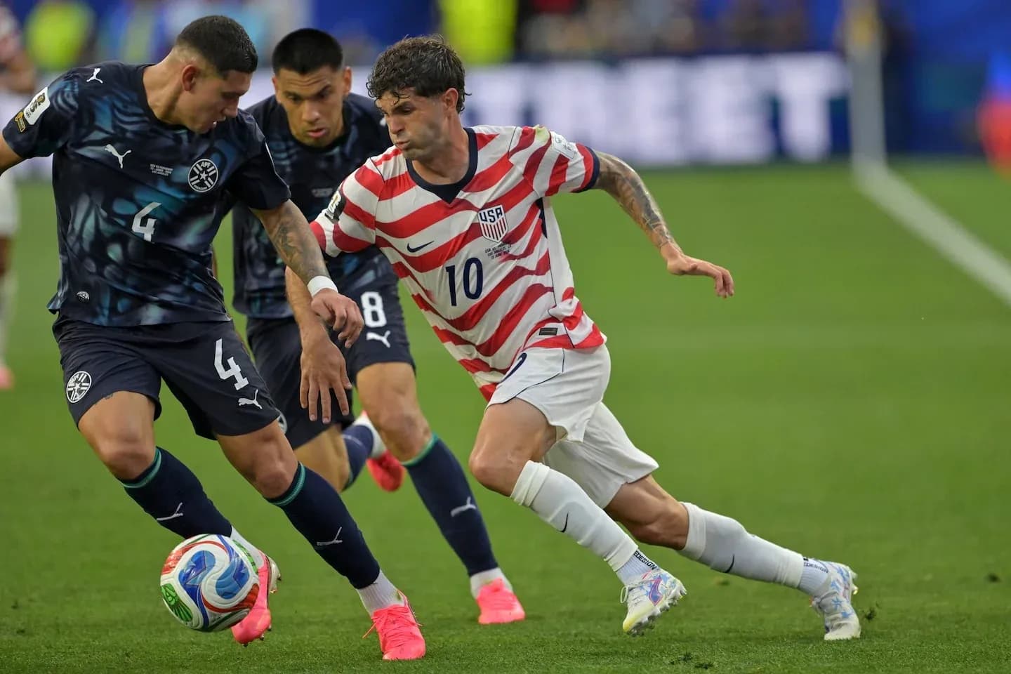 Christian Pulisic dribbling past Paraguayan defender