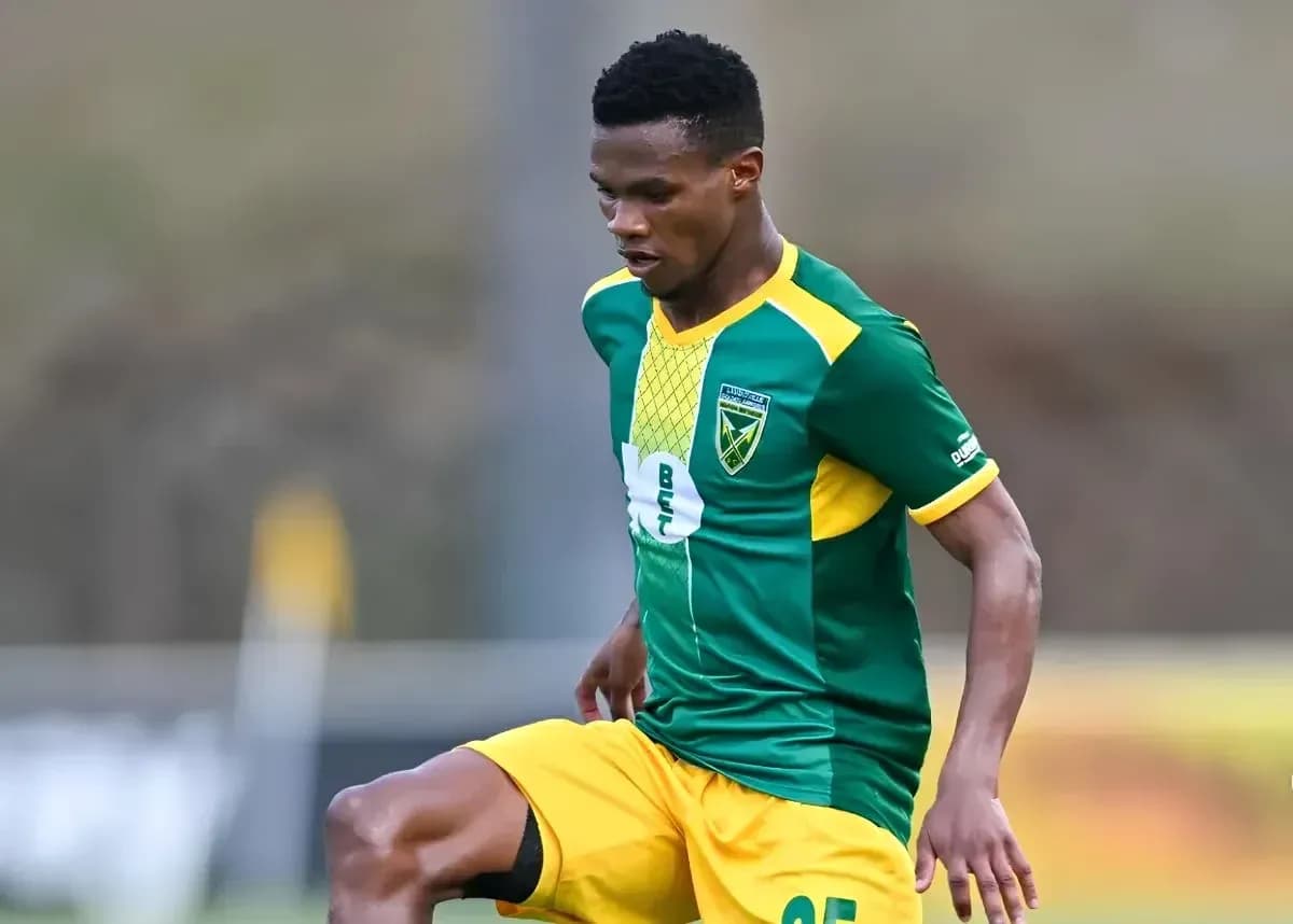 Jugador de fútbol en acción con camiseta verde y amarilla