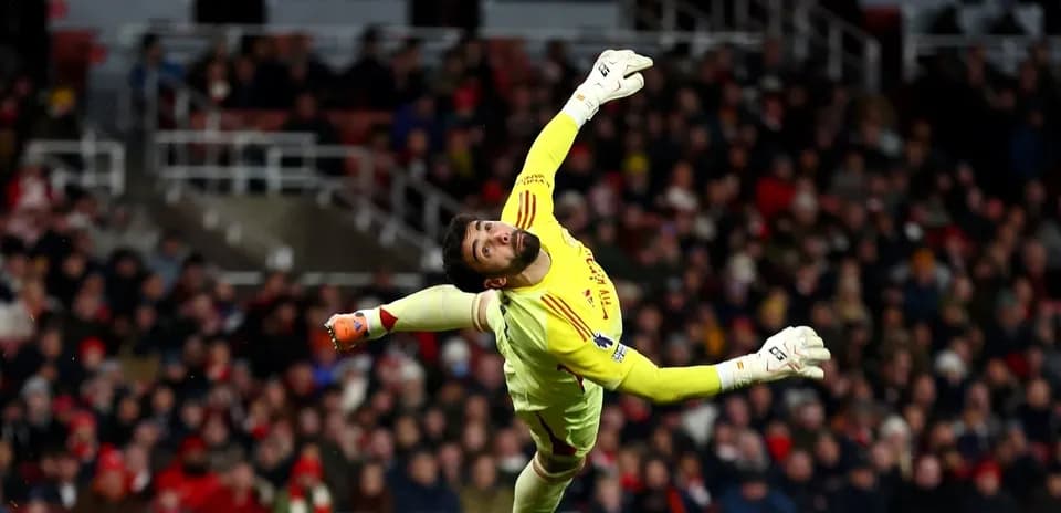 Portero lanzándose para detener un balón en el partido