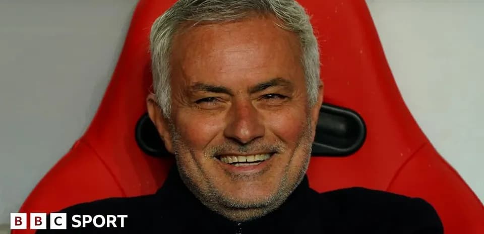 Entrenador sonriendo en el banquillo del partido