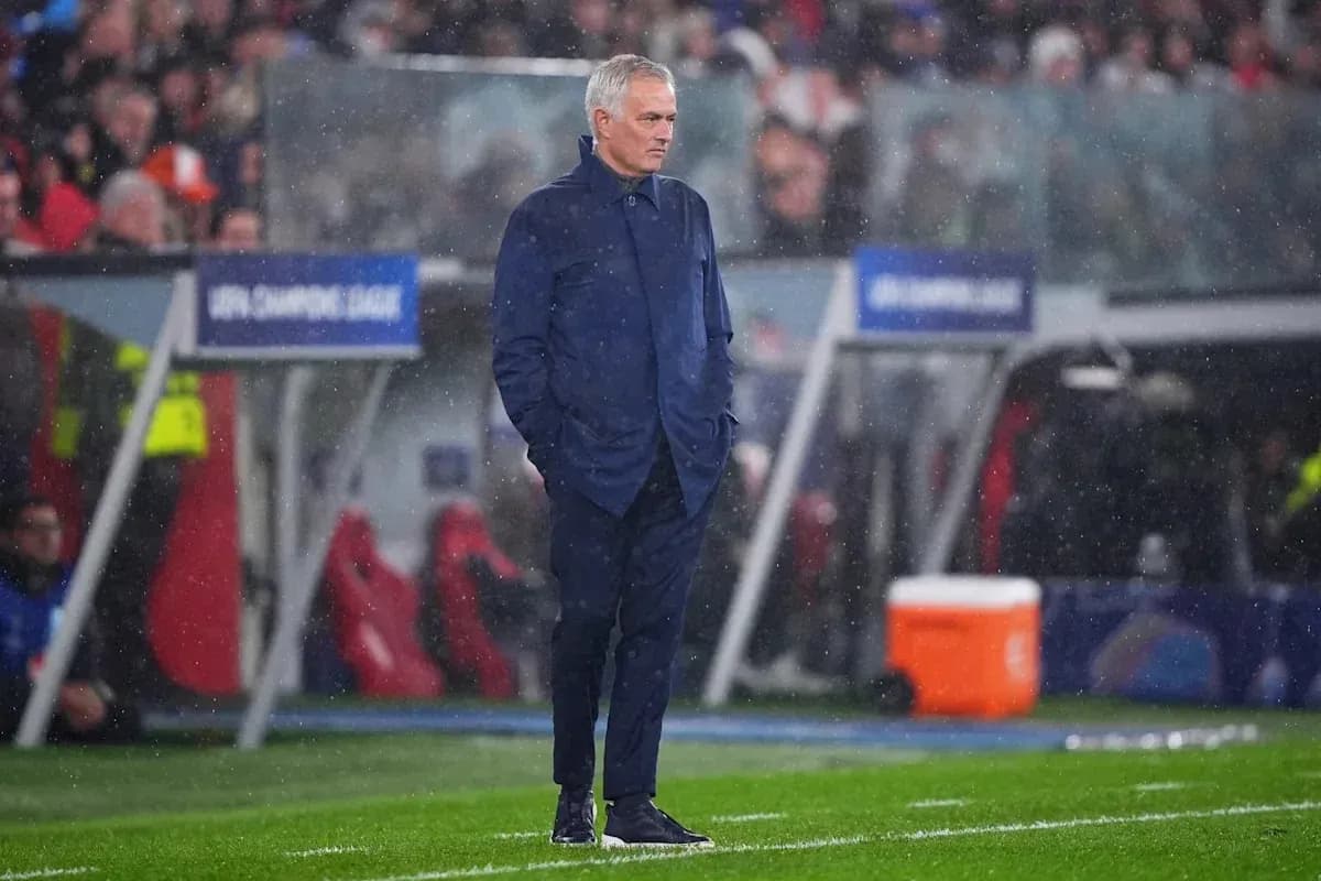 Entrenador en el banquillo durante un partido lluvioso