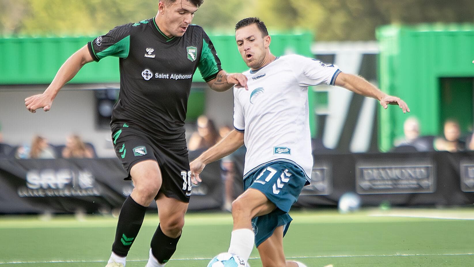Jugadores compitiendo por el balón en el partido Jugadores compitiendo por el balón en el partido