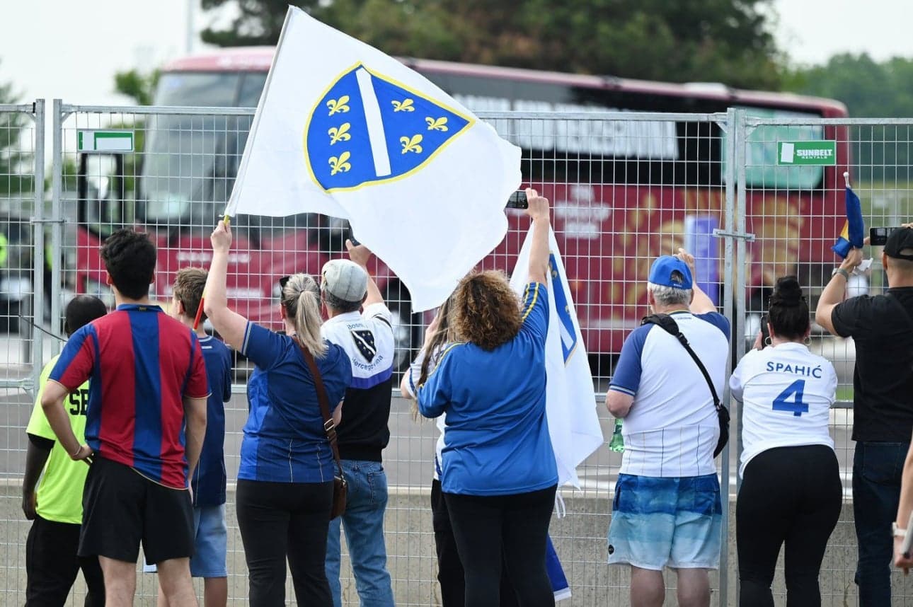 Aficionados sosteniendo banderas de Bosnia Aficionados sosteniendo banderas de Bosnia