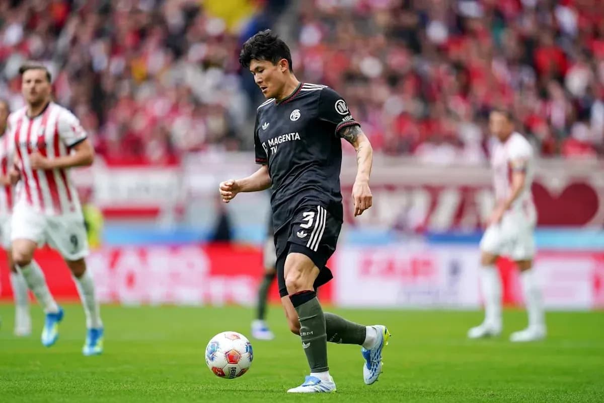Jugador controlando el balón en un partido de fútbol Jugador controlando el balón en un partido de fútbol