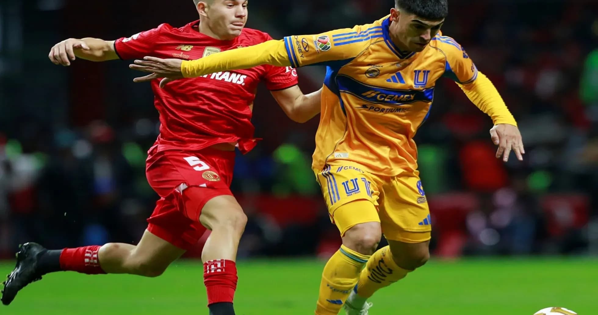 Jugadores de Toluca y Tigres luchando por el balón Jugadores de Toluca y Tigres luchando por el balón