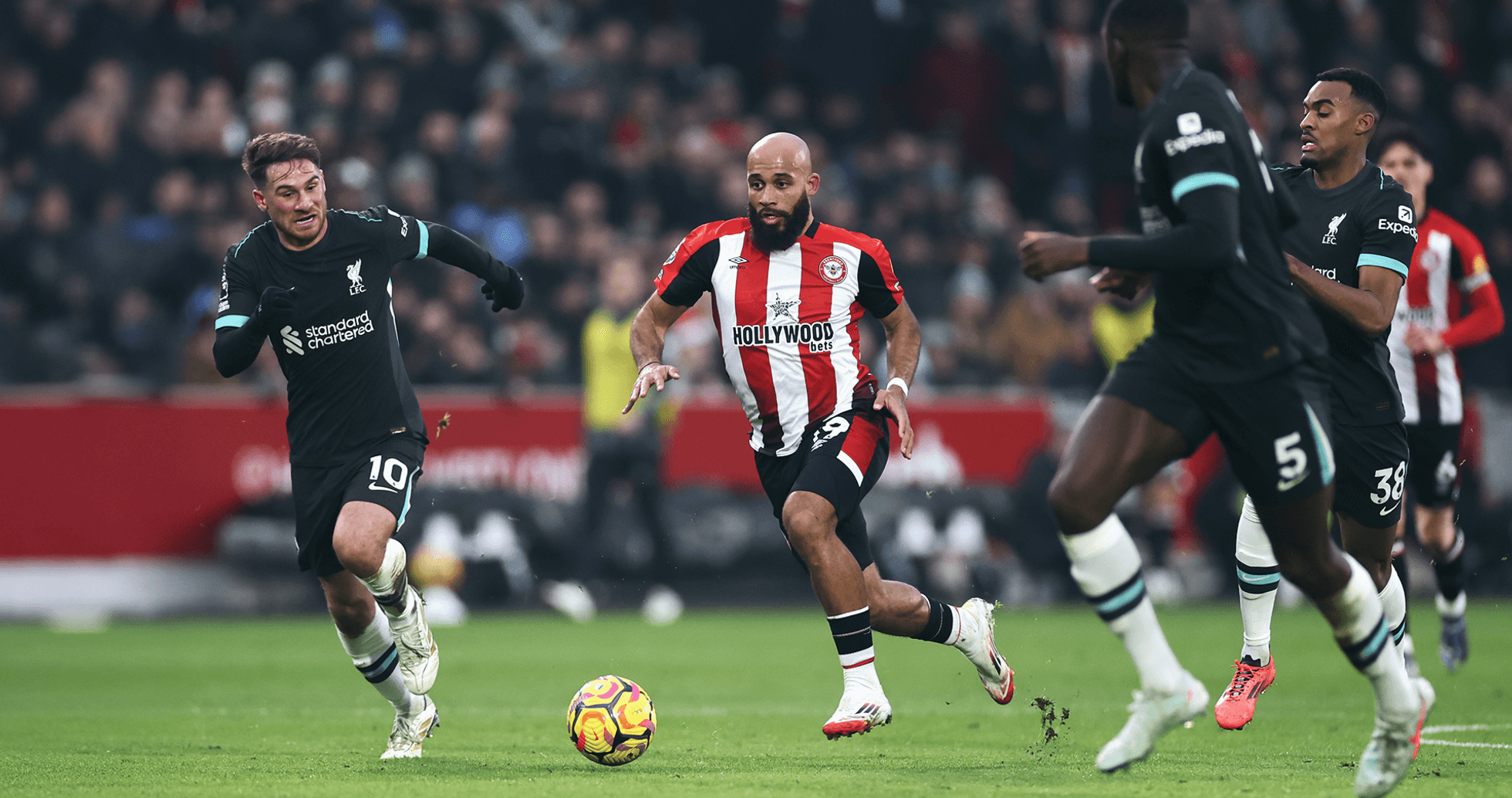 Jugador de Brentford esquivando a jugadores de Liverpool Jugador de Brentford esquivando a jugadores de Liverpool