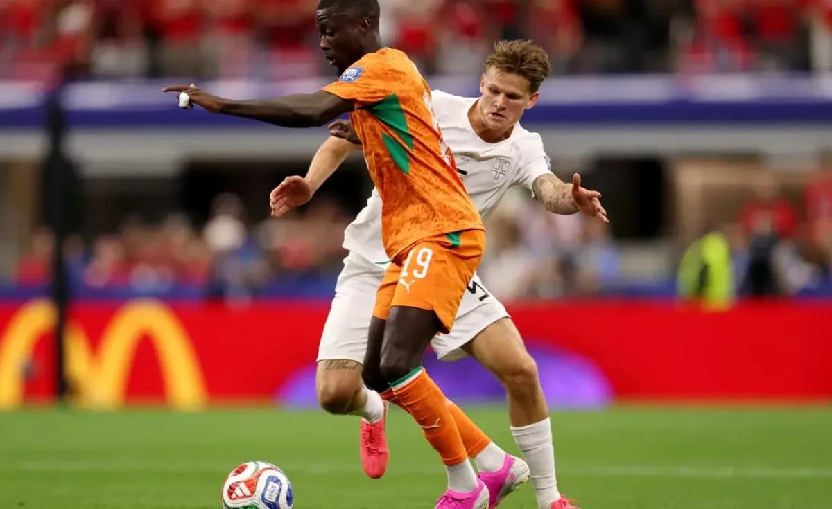 Jugador de Costa de Marfil driblando a rival inglés Jugador de Costa de Marfil driblando a rival inglés